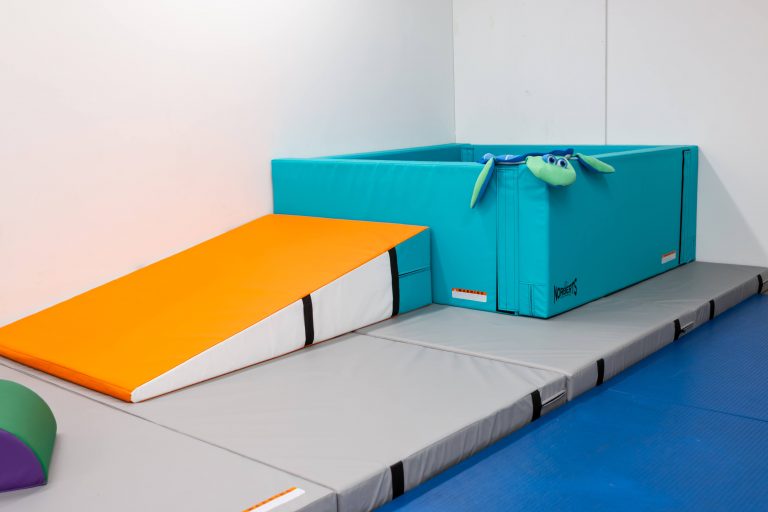 Foam wedge, gym mats, and crash pad set up for movement work
