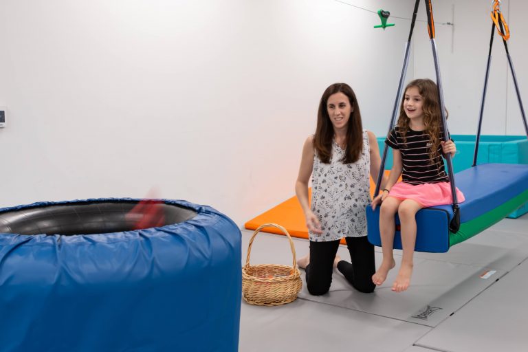 Therapist and child at the platform swing beside the crash pit
