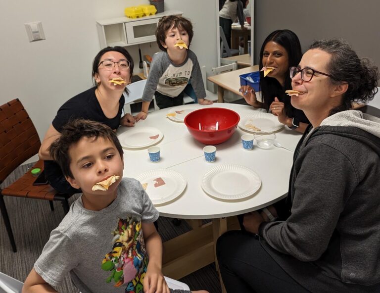 Children cooking together during a group feeding session in the Tumble N' Dots therapy kitchen