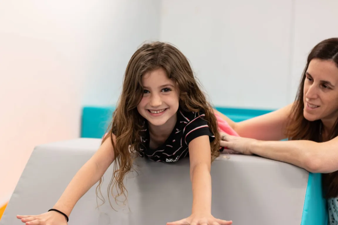 Pediatric occupational therapist working with a child in the sensory gym